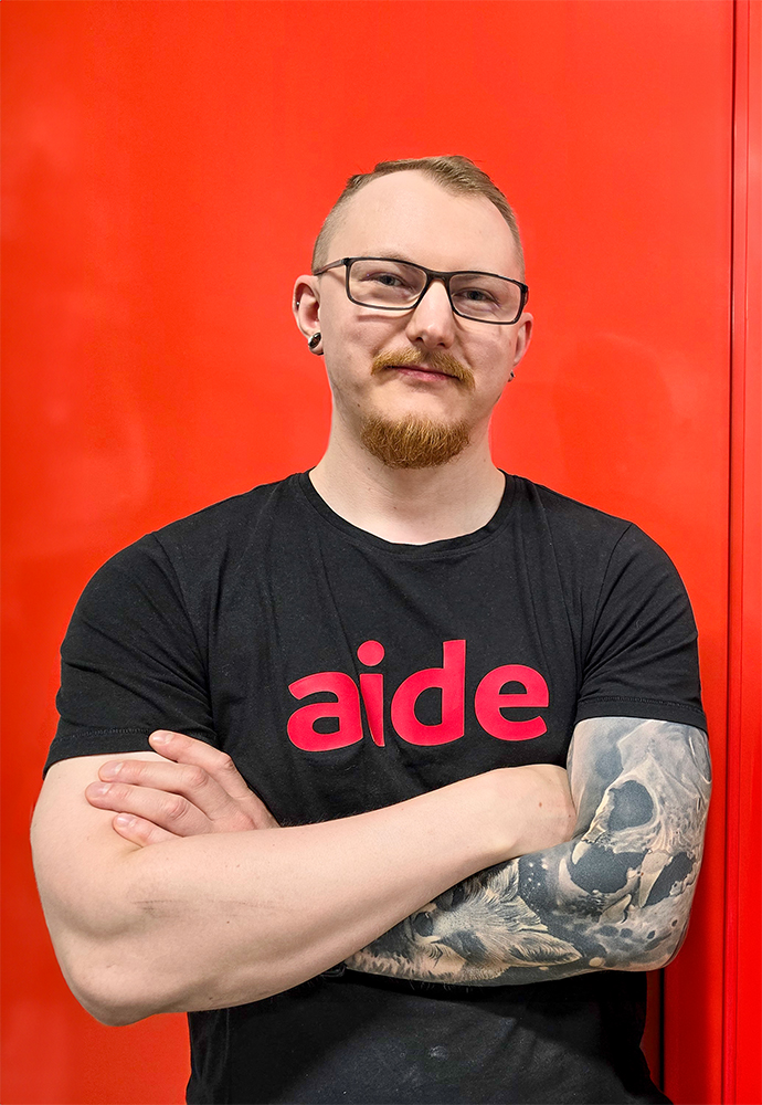 aiden työntekijä punaisen seinän edessä