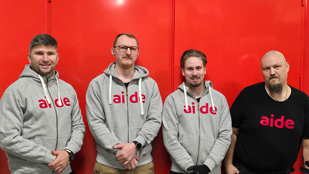 Aiden työntekijät rivissä punaisen oven edessä